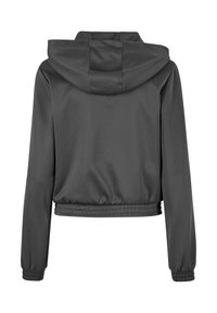 Giacca grigia a cappuccio tagliata, con polsini e orlo elasticizzati, caratterizzata da un tessuto liscio e un design semplice. La vista posteriore mostra il cappuccio e i dettagli delle cuciture.