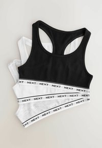 Drie tanktops in zwart, wit en grijs met een racerback ontwerp, voorzien van een opvallend "NEXT" logo op de elastische band.