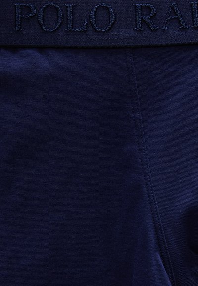Σκούρο ναυτικό μπλε ύφασμα με ορατή ραφή και το κέντημα "POLO RALPH LAUREN" με νήμα στο ίδιο χρώμα στη ζώνη μέσης.