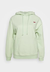 Mátově zelená mikina s kapucí vyrobená z měkké tkaniny. Obsahuje přední kapsu, nastavitelná stahovací šňůrka a malé logo na hrudi.