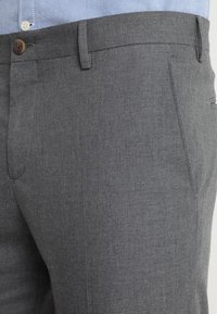Pantaloni grigi realizzati in un tessuto texturizzato, con chiusura a bottone, tasche laterali e una vestibilità sartoriale con design a gamba dritta.