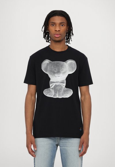 Black cotton t-shirt featuring a white graphic of a bear in a seated position. Short sleeves and round neckline. Light blue denim jeans.