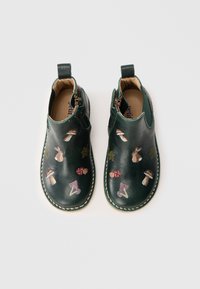 Botas de tobillo de cuero verde con bordados de setas, conejos y hojas. Cierre lateral con cremallera y costuras decorativas a lo largo de la suela.