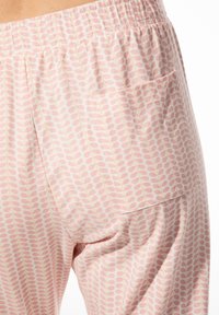 Lichtroze pyjamabroek met een subtiel bladenpatroon, met een elastische tailleband en een zijzak met verticale naden.