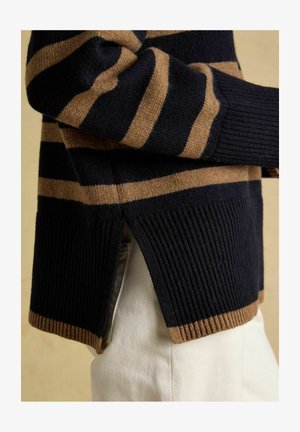 Streifenpullover in Marineblau und Beige mit geripptem Saum und seitlichen Schlitzen. Weiche Textur, lockere Passform und kontrastierende Farben.
