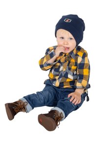 Bambino con un berretto blu navy, camicia a quadri gialli e blu e pantaloni di jeans arrotolati. Indossa stivali marroni con lacci e suola texturizzata.