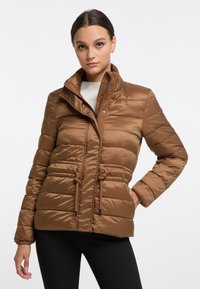 Giacca a vento marrone con colletto alto, chiusura con zip e bottoni a pressione, polsini elasticizzati e vita con cordoncino. Tessuto in nylon liscio e lucido con motivo trapuntato.