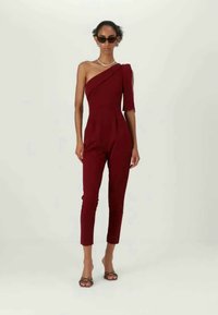 Βουργουνδίας ολόσωμο φορμάκι με έναν ώμο, εφαρμοστή γραμμή, κομμένα πόδια, απαλή υφή, με πλευρική σχισμή και διακριτές πτυχώσεις τύπου τύμπανο. Ελαφρύ ύφασμα.