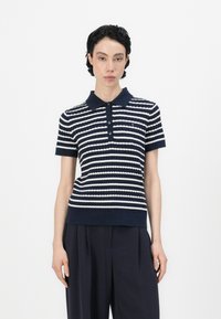 Tamsiai mėlynas ir baltas dryžuotas polo marškinėliai su raštuotu tekstūru, turintis apykaklės iškirpimą ir tris mygtukus. Trumpomis rankovėmis, prigludusio silueto.