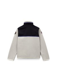 Fleecepullover i ljusgrå och svart med hög krage, kontrasterande blå sömmar och en rund lapp på vänster ärm.