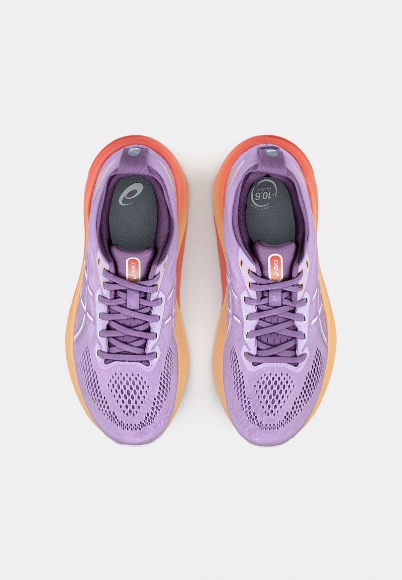 Zapatillas moradas con una parte superior de malla transpirable, acentos grises y una suela naranja degradada. Presenta cordones morados y una puntera con diseño.