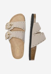 Infradito beige con due ampie cinghie, borchie dorate e fibbie coordinate. Soletta morbida e suola in gomma nera texturizzata.