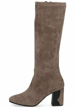 Botte en suède taupe, arrivant jusqu'aux genoux, avec un bout pointu et une finition texturée. Présente un talon noir épais avec une découpe géométrique distincte.