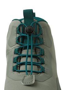 Zapatilla impermeable verde con un diseño elegante. Presenta un sistema de cordones rápido, una parte superior texturizada y acentos en color teal en contraste.