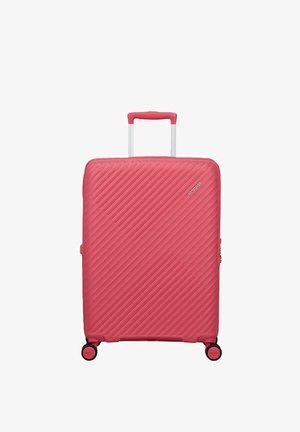 Valigia rigida rossa con scanalature diagonali, manico telescopico, quattro ruote e piccolo logo nell'angolo in alto a destra.