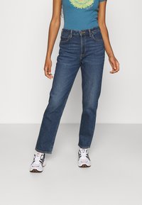 Jeans en denim bleu taille haute avec une coupe droite, présentant un design classique à cinq poches et de subtils détails de couture.