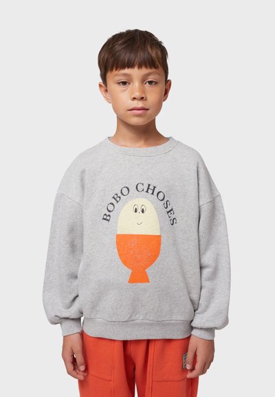 Sudadera gris de corte relajado, con un gráfico colorido de un huevo en naranja y amarillo, con la marca "BOBO CHOSES" en texto negro.