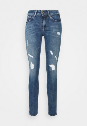 Blaue Skinny-Jeans mit abgenutzten Stellen an den vorderen Oberschenkeln und Knien, ausgestattet mit vorderem Knopf, Reißverschluss und Fünf-Taschen-Design.