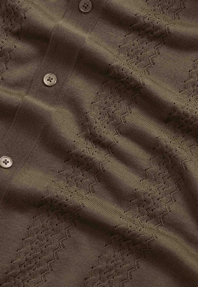 Tissu marron tricoté avec un motif en dentelle zigzag et trois boutons marron à quatre trous alignés au centre.