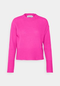 Jasnoróżowy sweter z długim rękawem, z prążkowanym wykończeniem na dekolcie i mankietach. Wykonany z miękkiego, lekkiego materiału, o luźnym, krótkim kroju.