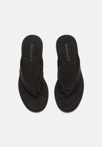 Black flip-flops with a soft textured footbed and sleek leather straps. Features Timberland logo on insoles and contrasting stitching.
