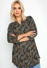 Czarna bluzka zapinana na guziki z kolorowym, wzorzystym nadrukiem w odcieniach zieleni, pomarańczu i bieli. Posiada rękawy o długości trzech czwartych oraz luźny krój.