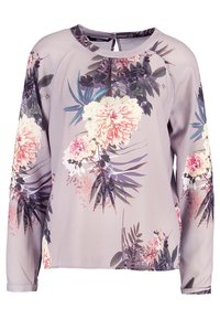 Langærmet bluse i lys lavendelfarvet stof med et blomsterprint bestående af pink og lilla blomster, grønne blade samt en rund halsudskæring.