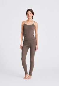 Brauner, leichter, taillierter Tanktop mit dünnen Trägern, kombiniert mit passenden Leggings mit einem strukturierten Muster, geeignet für legere Kleidung.
