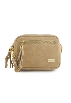 Sac bandoulière rectangulaire en daim beige avec fermeture éclair dorée, tirette pompon, sangle réglable et petite plaque logo métallique.