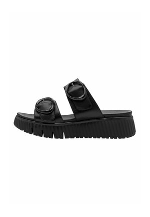 Schwarze Ledersandalen zum Hineinschlüpfen mit zwei runden Schnallendetails, dicker gerippter Sohle, offenem Zehendesign und glatter Textur.