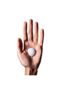 En hvit kremklump hviler i en åpen, lysfarget hånd med lange fingre og en teksturert håndflate mot en enkel bakgrunn.