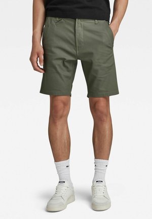 Szorty oliwkowe wykonane z mieszanki bawełny; mające prosty krój, dwa przednie kieszenie i płaską przednią część. Idealne do codziennego noszenia.