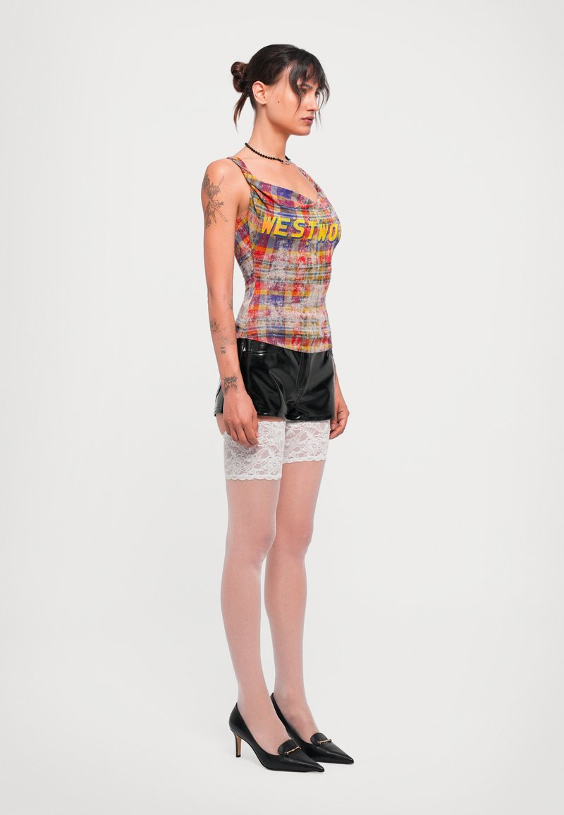 Black satin shorts with lace trim, multicolored woven tank top featuring the word "WESTIN," sheer nude tights, and black pointed heels.