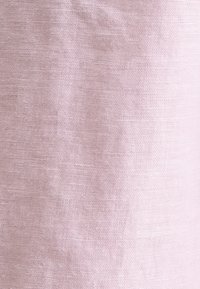 Lichtroze linnen stof met een textuur, met een iets onregelmatige weving en natuurlijke zachtheid. Ideaal voor ademende kleding of meubels.