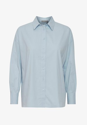 Camicia azzurra chiara con colletto classico, patta dei bottoni e maniche lunghe a palloncino. Realizzata in tessuto morbido con una vestibilità leggermente rilassata.