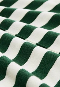 Tissu rayé vert et blanc avec une texture douce. Les rayures sont ondulées, alternant en couleur et en largeur, avec une finition légèrement floue.