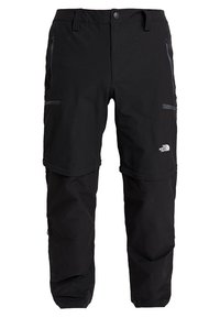 Pantalon de plein air convertible noir avec jambes inférieures amovibles par zip, poches zippées, fermeture à boutons, et logo The North Face sur la cuisse droite.