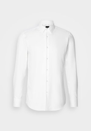 Chemise blanche à manches longues avec boutons, fabriquée dans un tissu lisse, dotée d'un col classique et d'un ourlet droit avec des détails de couture subtils.