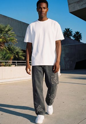 Karl Kani, RELAXED FIT FLARED JEANS WITH WORN K PATCHES - Jean coupe décontractée - grey