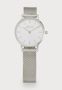 Orologio con cinturino in maglia argento che presenta un quadrante rotondo bianco con indicatori delle ore minimalisti e il nome del marchio "LIU-JO" ben in evidenza.