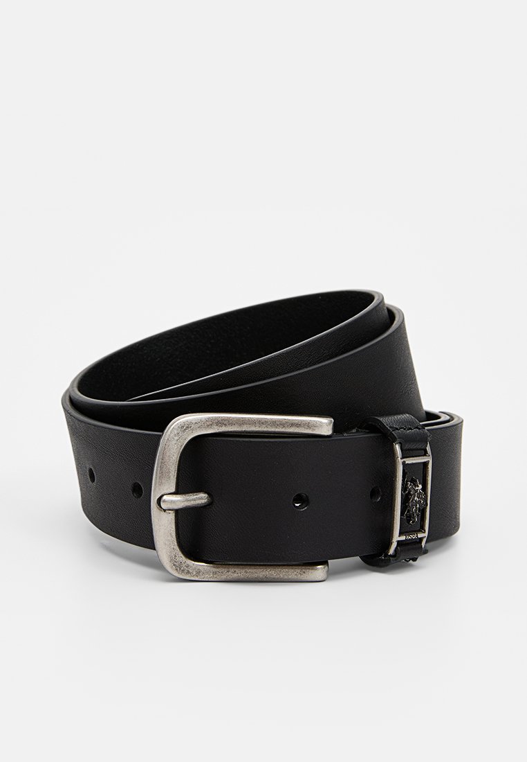 Zwarte leren riem met een zilveren metalen gesp, voorzien van een gestructureerde afwerking en een klein logo-detail nabij de gesp. Verstelbare lengte.