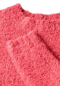 Teksturowana tkanina w jasnoróżowym kolorze, z puszystymi, krótkimi włóknami, które nadają miękki wygląd. Materiał wydaje się lekki i przytulny.