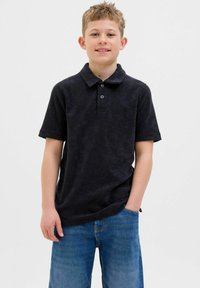 Čierne polo tričko vyrobené z mäkkej tkaniny, s golierom, trojbuttonovou légou a krátkymi rukávmi, skombinované so svetlomodrými riflovými šortkami.