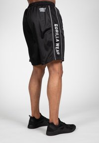 Zwarte sportieve shorts van mesh stof, met zijstrepen en het logo "GORILLA WEAR" in het wit aan de linkerkant.