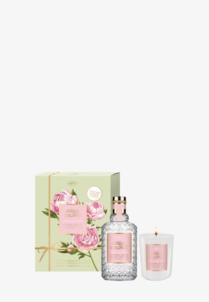 Acqua Colonia peony and sandalwood cologne bottle, matching scented candle with flame, and floral gift box with pink peony design.