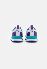 Chaussures de sport avec un design violet, blanc et bleu sarcelle, une tige texturée, un col rembourré et un talon renforcé. Logo PUMA à l'arrière.