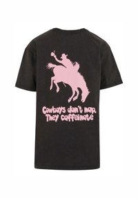Črna majica iz bombaža, z rožnatim grafičnim motivom kavboja in napisom "Kavboji ne spite. Kafinirate" na hrbtni strani. Kratki rokavi.