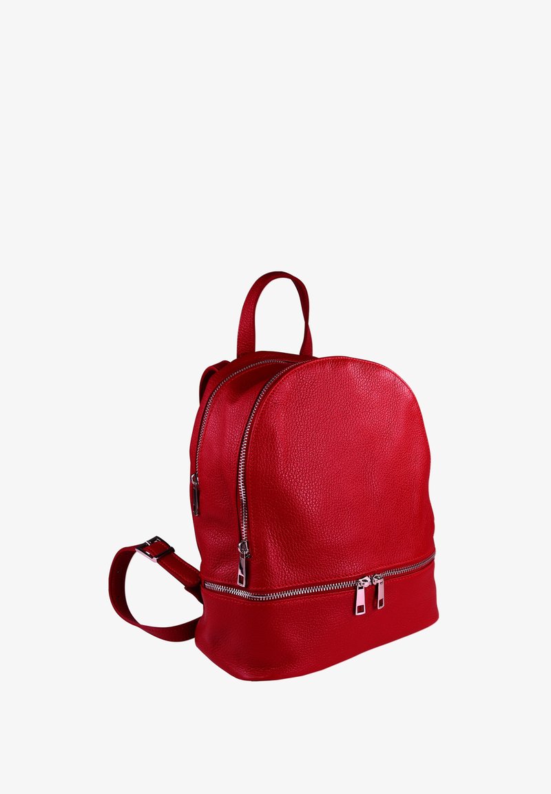 Sac à dos en cuir rouge avec une forme arrondie, équipé de deux zips et d'une poignée supérieure. Surface texturée avec une finition douce et des bretelles ajustables.