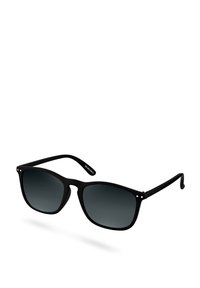Gafas de sol negras con un acabado mate, forma cuadrada, lentes con degradado gris y pequeños orificios decorativos en la montura. Reflexión de luz visible.