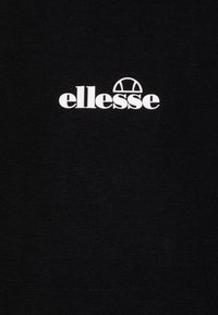 Černé bavlněné tričko s výrazným bílým logem "ellesse" a zakřiveným akcentem nad textem, hladká textura a klasický design.